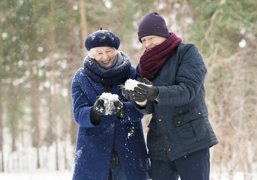 older couple making snowballs - staying active autum